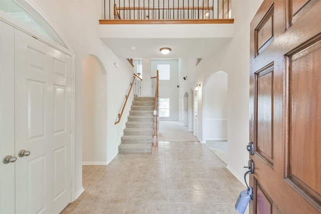 entrance foyer featuring light tile patterned floors and a high ceiling