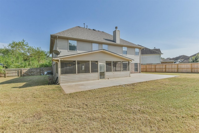 back of property with a yard, a sunroom, and a patio