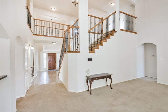 stairs with a towering ceiling and carpet floors