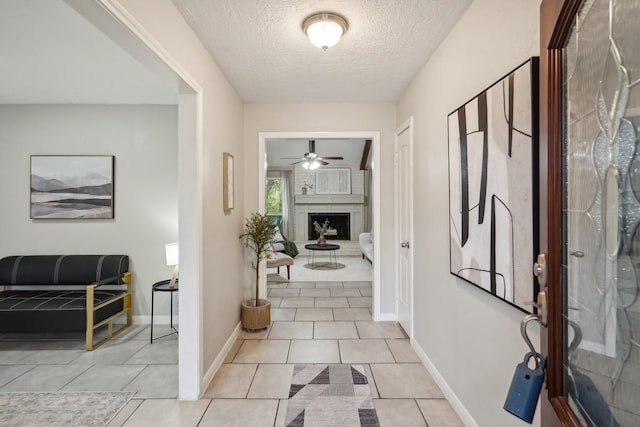 hall with light tile patterned floors and a textured ceiling