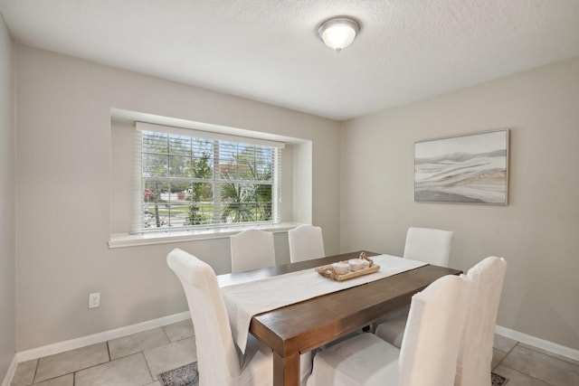 dining room featuring light tile patterned flooring and a textured ceiling