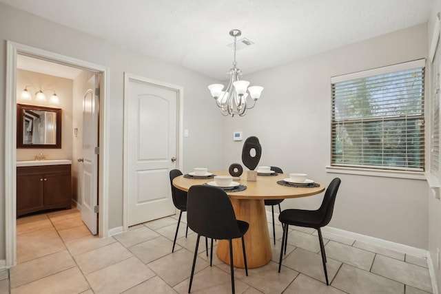 tiled dining space featuring sink and a chandelier