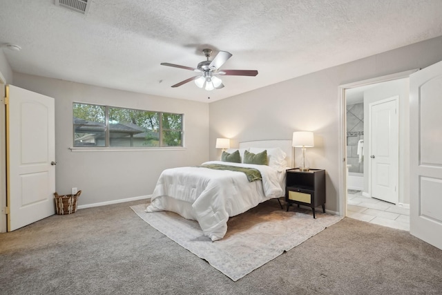 bedroom with a textured ceiling, ceiling fan, light colored carpet, and ensuite bathroom