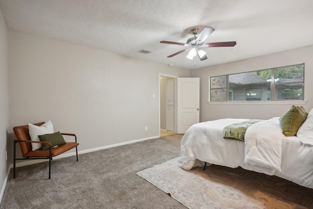 bedroom featuring carpet, ceiling fan, and a textured ceiling