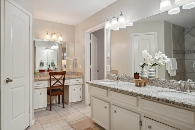 bathroom with a tile shower, tile patterned flooring, and vanity