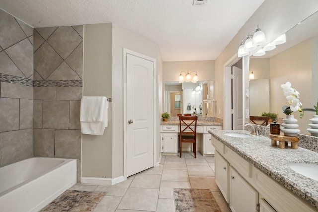 bathroom with tile patterned flooring, vanity, a textured ceiling, and a washtub