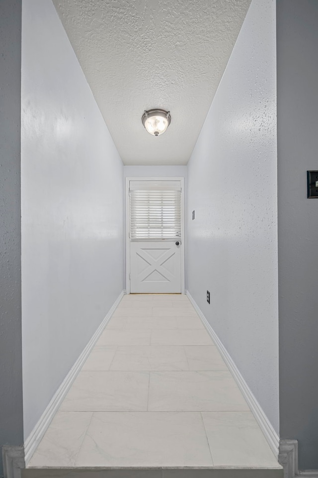 hallway with a textured ceiling