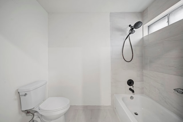 bathroom featuring tiled shower / bath and toilet