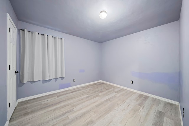 empty room with light hardwood / wood-style flooring