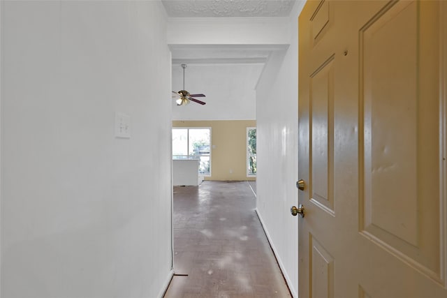 hallway with hardwood / wood-style floors, a textured ceiling, and a high ceiling