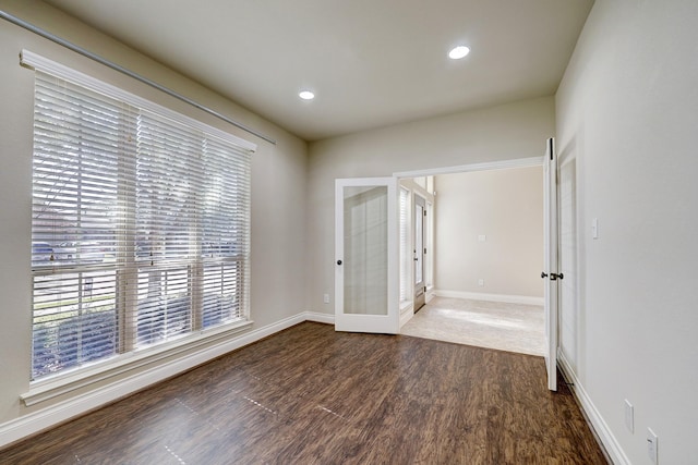 spare room featuring dark hardwood / wood-style flooring and french doors