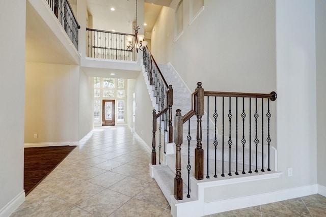 foyer featuring hardwood / wood-style floors, a towering ceiling, and an inviting chandelier