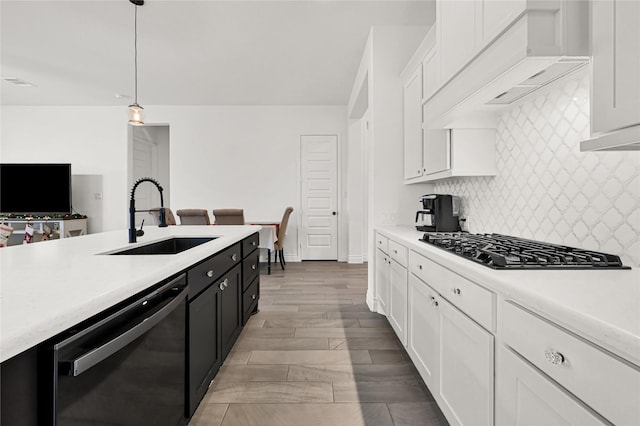 kitchen featuring white cabinets, appliances with stainless steel finishes, pendant lighting, and sink