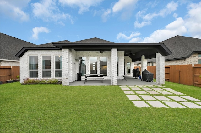 rear view of house featuring a patio, ceiling fan, and a lawn