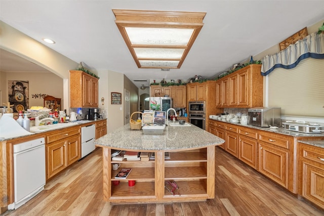 kitchen with a center island with sink, light hardwood / wood-style flooring, stainless steel appliances, and sink