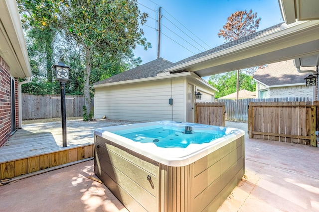 view of patio / terrace with a hot tub and a deck