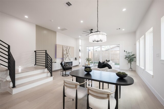 dining space featuring ceiling fan, a premium fireplace, and light wood-type flooring