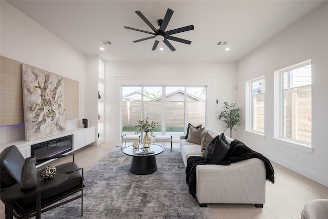 living room with ceiling fan and light wood-type flooring