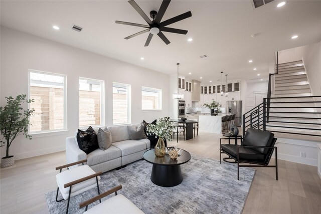 living room featuring ceiling fan, a healthy amount of sunlight, and light hardwood / wood-style floors