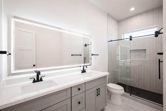 bathroom with vanity, toilet, and a shower with door