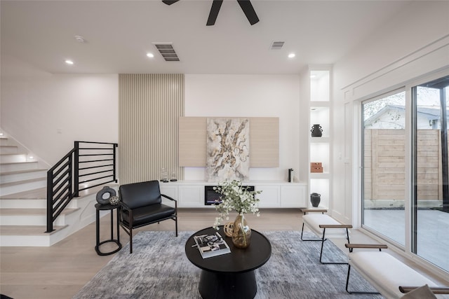 sitting room with ceiling fan and light hardwood / wood-style flooring