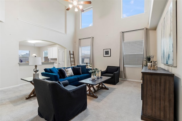 living room with light carpet, a high ceiling, plenty of natural light, and ceiling fan