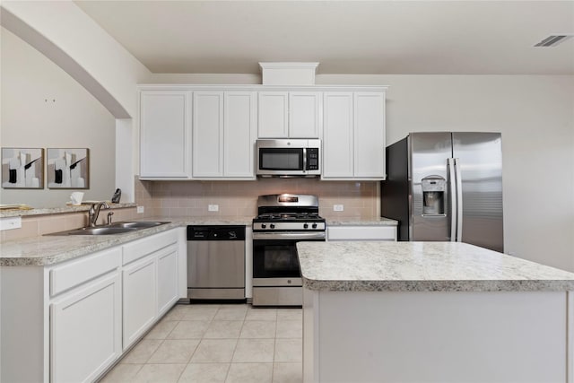 kitchen featuring light tile patterned floors, decorative backsplash, stainless steel appliances, light countertops, and a sink