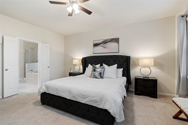 bedroom featuring light carpet, ensuite bathroom, and ceiling fan