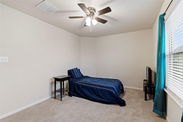 carpeted bedroom featuring baseboards, visible vents, and a ceiling fan