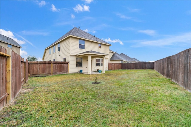 back of house with a lawn and a fenced backyard