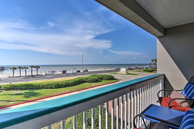 balcony featuring a beach view and a water view