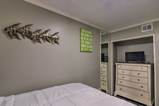 bedroom with a textured ceiling and ornamental molding