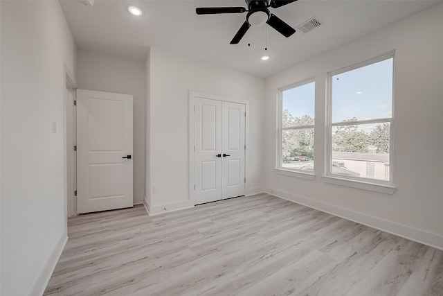 unfurnished bedroom featuring a closet, ceiling fan, and light hardwood / wood-style flooring