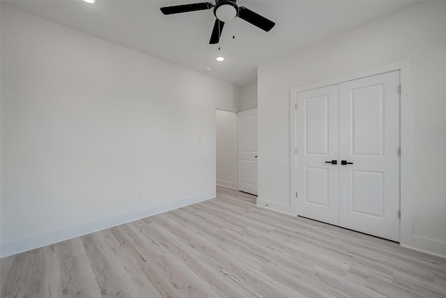 unfurnished bedroom featuring ceiling fan, light hardwood / wood-style floors, and a closet