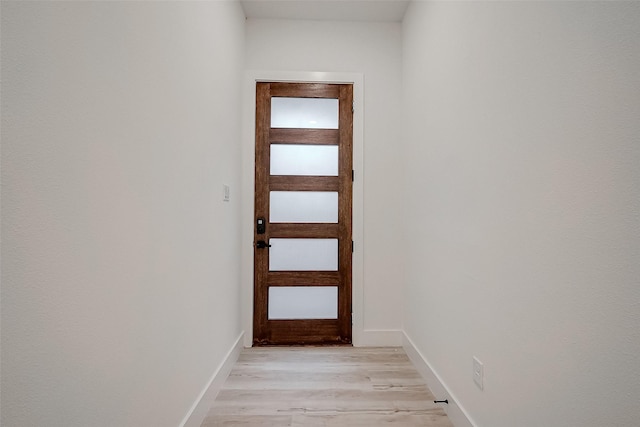 doorway to outside featuring light wood-style flooring and baseboards