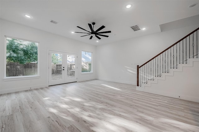 unfurnished living room featuring ceiling fan, french doors, and light wood-type flooring