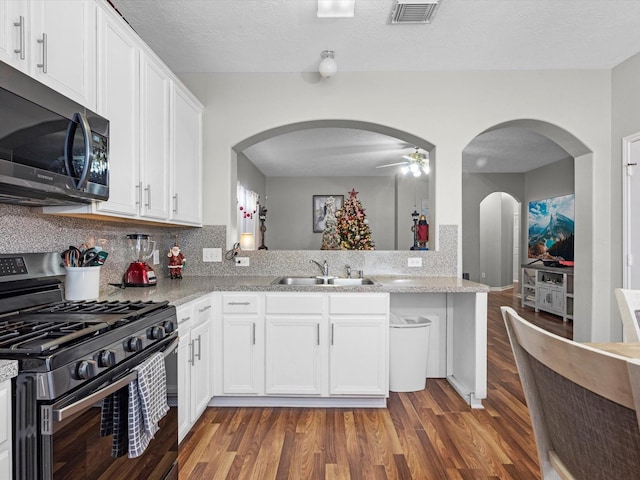 kitchen featuring dark hardwood / wood-style floors, sink, white cabinetry, and stainless steel appliances