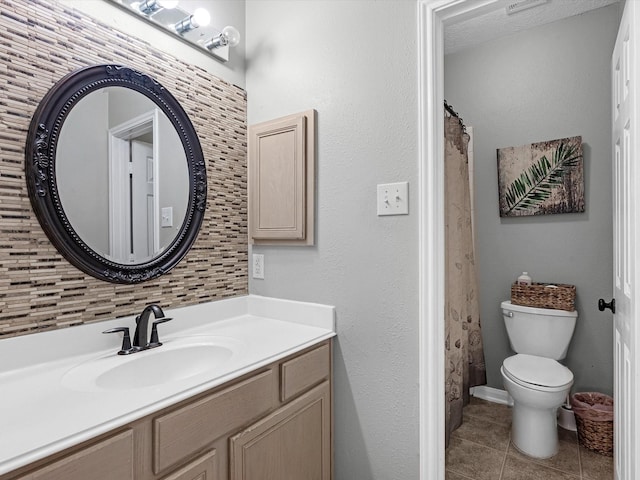 bathroom featuring tile patterned flooring, vanity, tasteful backsplash, and toilet