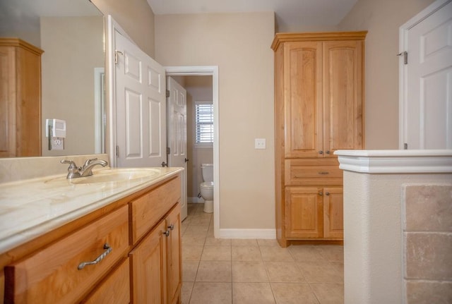 bathroom with tile patterned flooring, vanity, and toilet