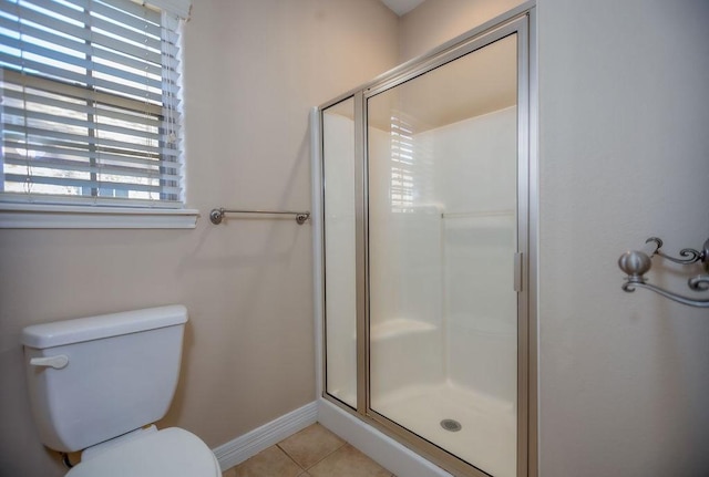 bathroom featuring tile patterned floors, toilet, and walk in shower