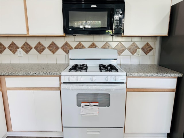 kitchen with white cabinets, fridge, white range with gas cooktop, and tasteful backsplash