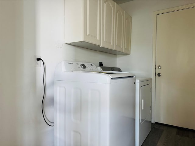 laundry room featuring dark hardwood / wood-style floors, washer and dryer, and cabinets