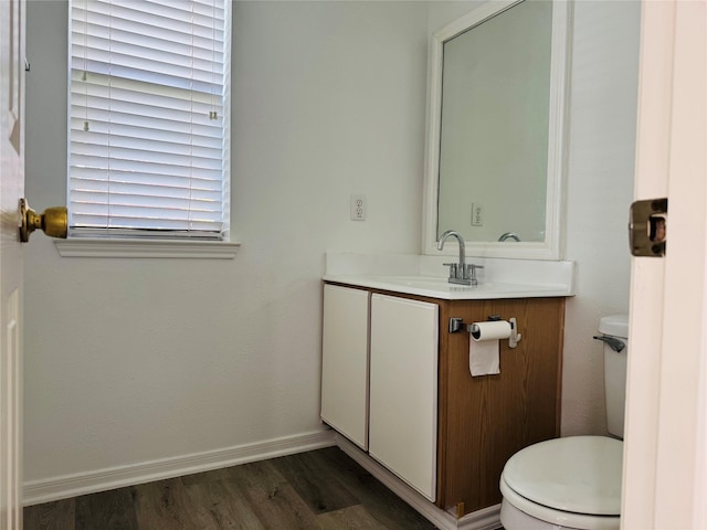 bathroom with hardwood / wood-style floors, vanity, toilet, and a wealth of natural light