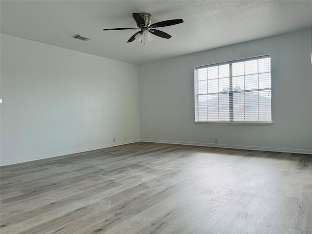 unfurnished room featuring ceiling fan, light hardwood / wood-style flooring, and a textured ceiling