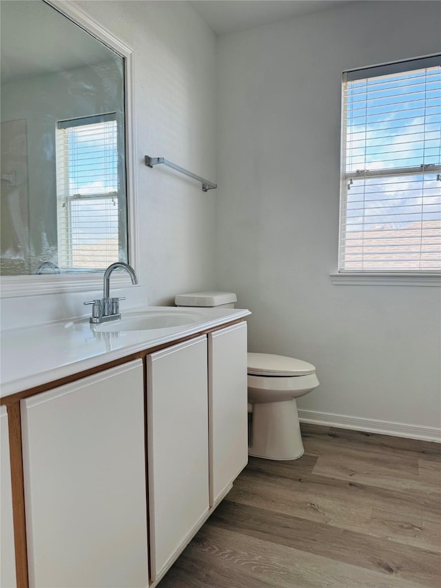 bathroom with hardwood / wood-style floors, vanity, and toilet