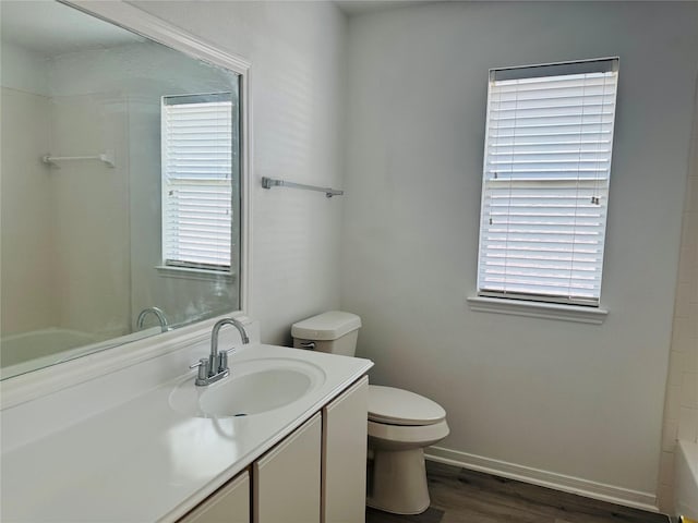 full bathroom with hardwood / wood-style floors, plenty of natural light, toilet, and vanity