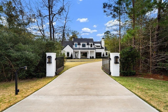 7010 Bowie Ct, Montgomery, TX 77316 - view of front of house with a gate, a chimney, concrete driveway, and a fenced front yard