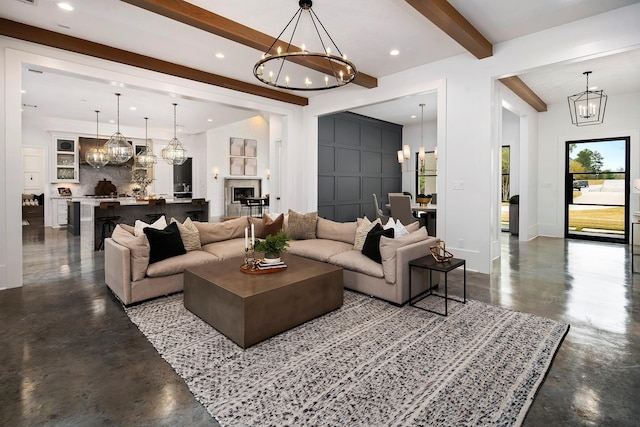 living room featuring beam ceiling, concrete floors, and an inviting chandelier