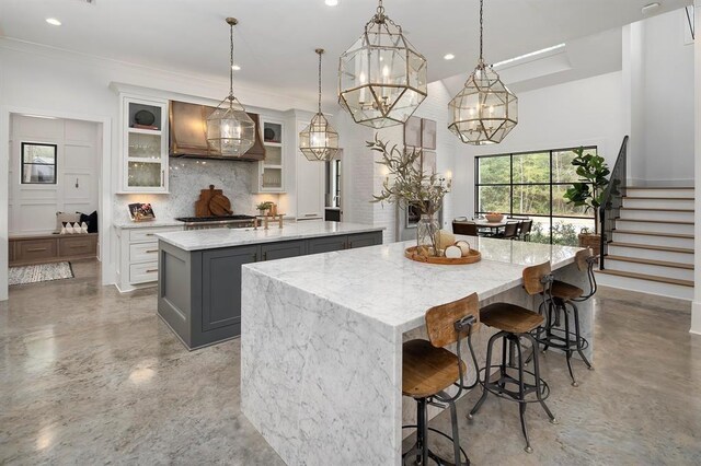 7010 Bowie Ct, Montgomery, TX 77316 - kitchen with a large island with sink, decorative backsplash, wall chimney range hood, recessed lighting, and concrete flooring