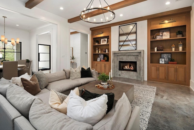 living room with beamed ceiling, a premium fireplace, concrete flooring, and an inviting chandelier